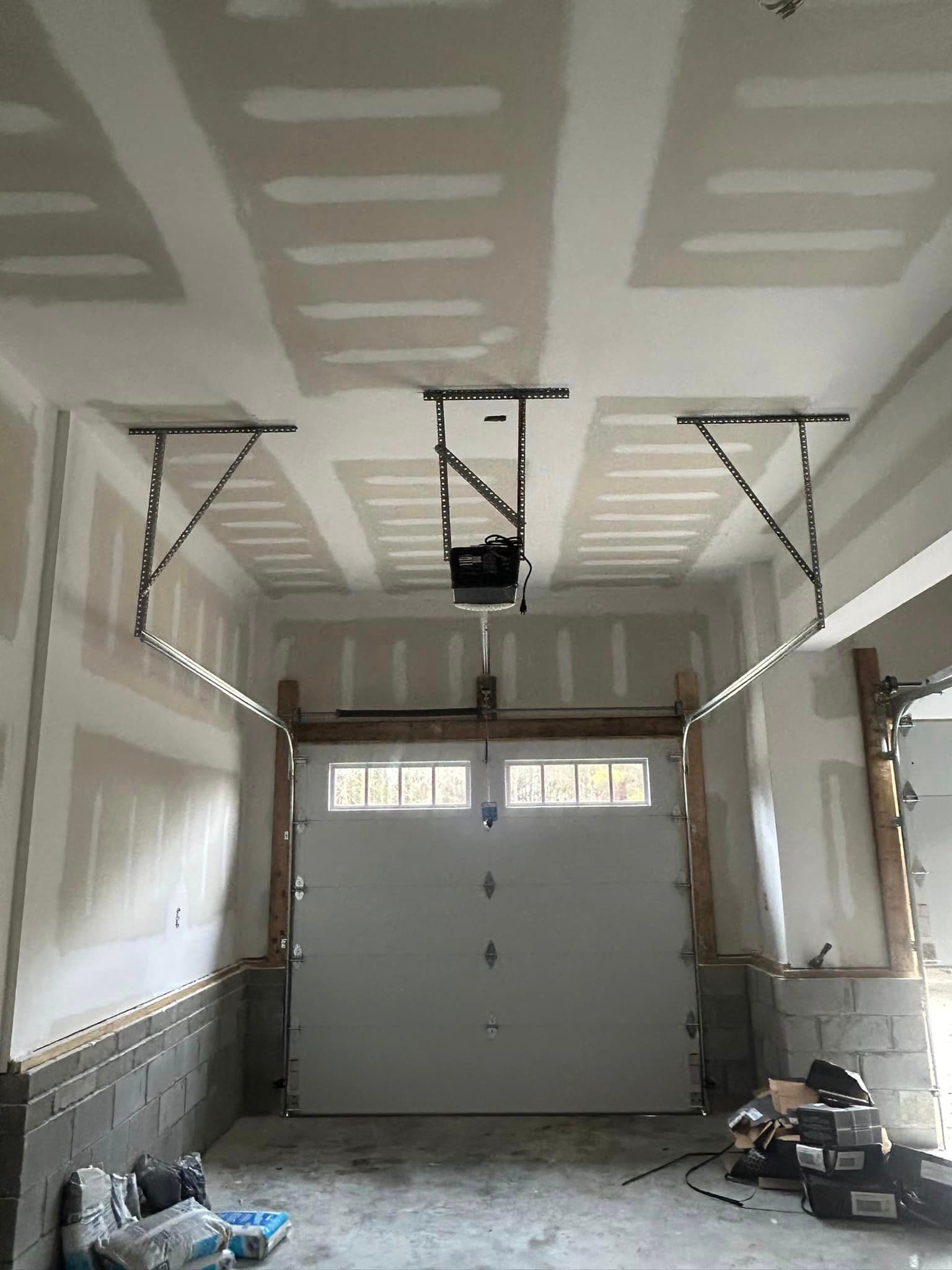 A garage with a garage door open and a ceiling fan.