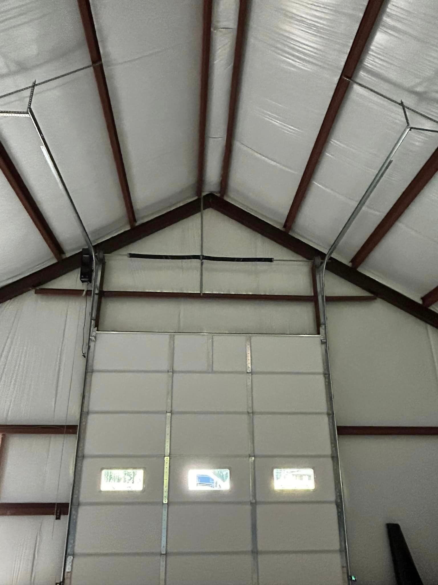 A large white garage door is open in a building.