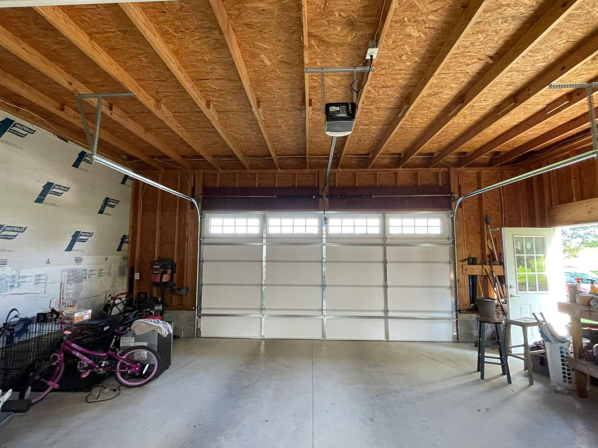 A garage with a garage door open and a bicycle in it.