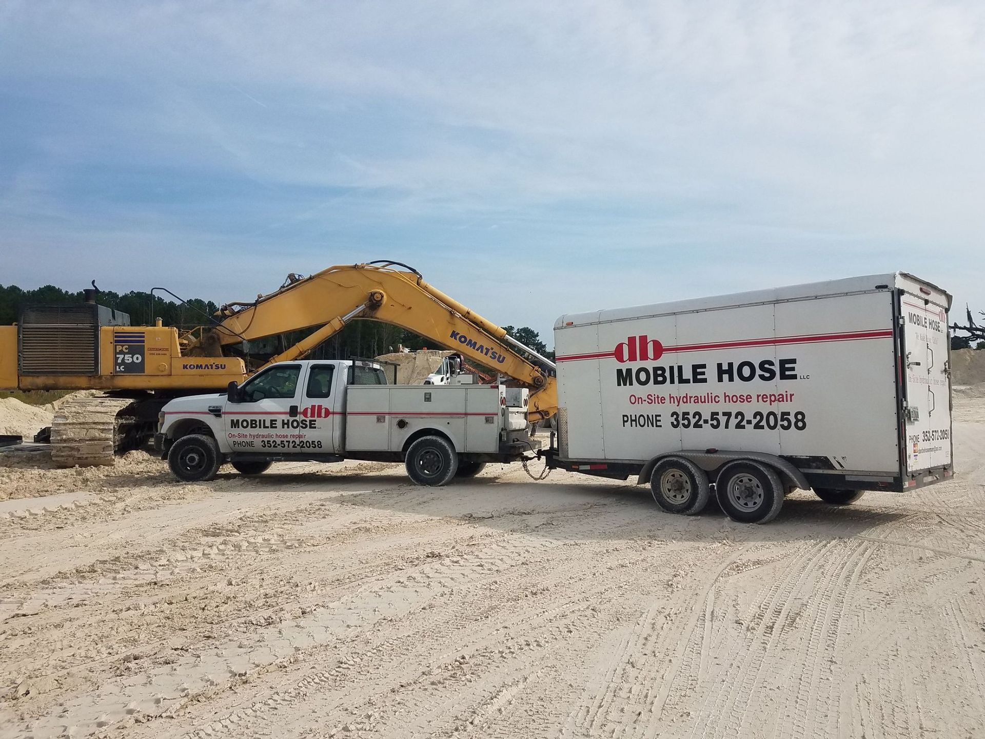 Mobile Hose truck and trailer on a construction site, with an excavator.