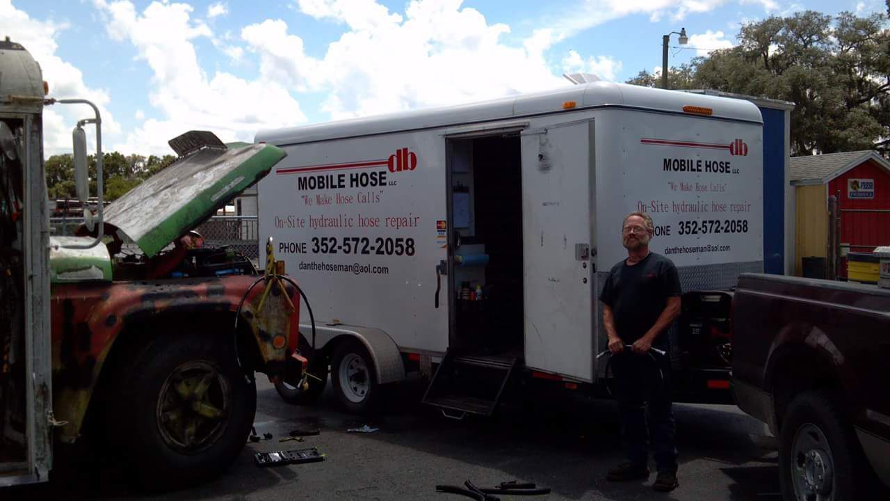 Man stands by a white trailer with 