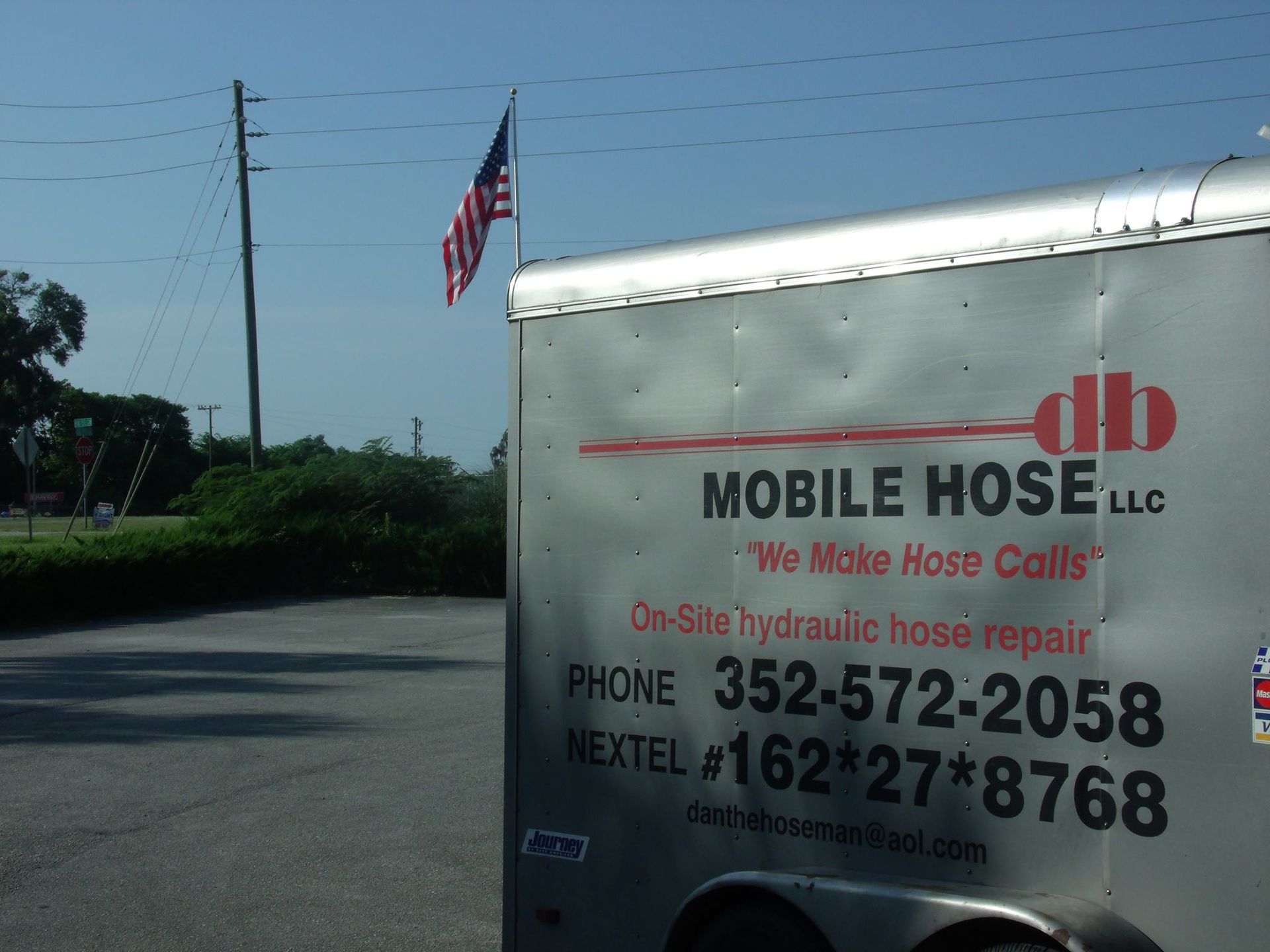 Mobile Hose LLC trailer with US flag and phone numbers.