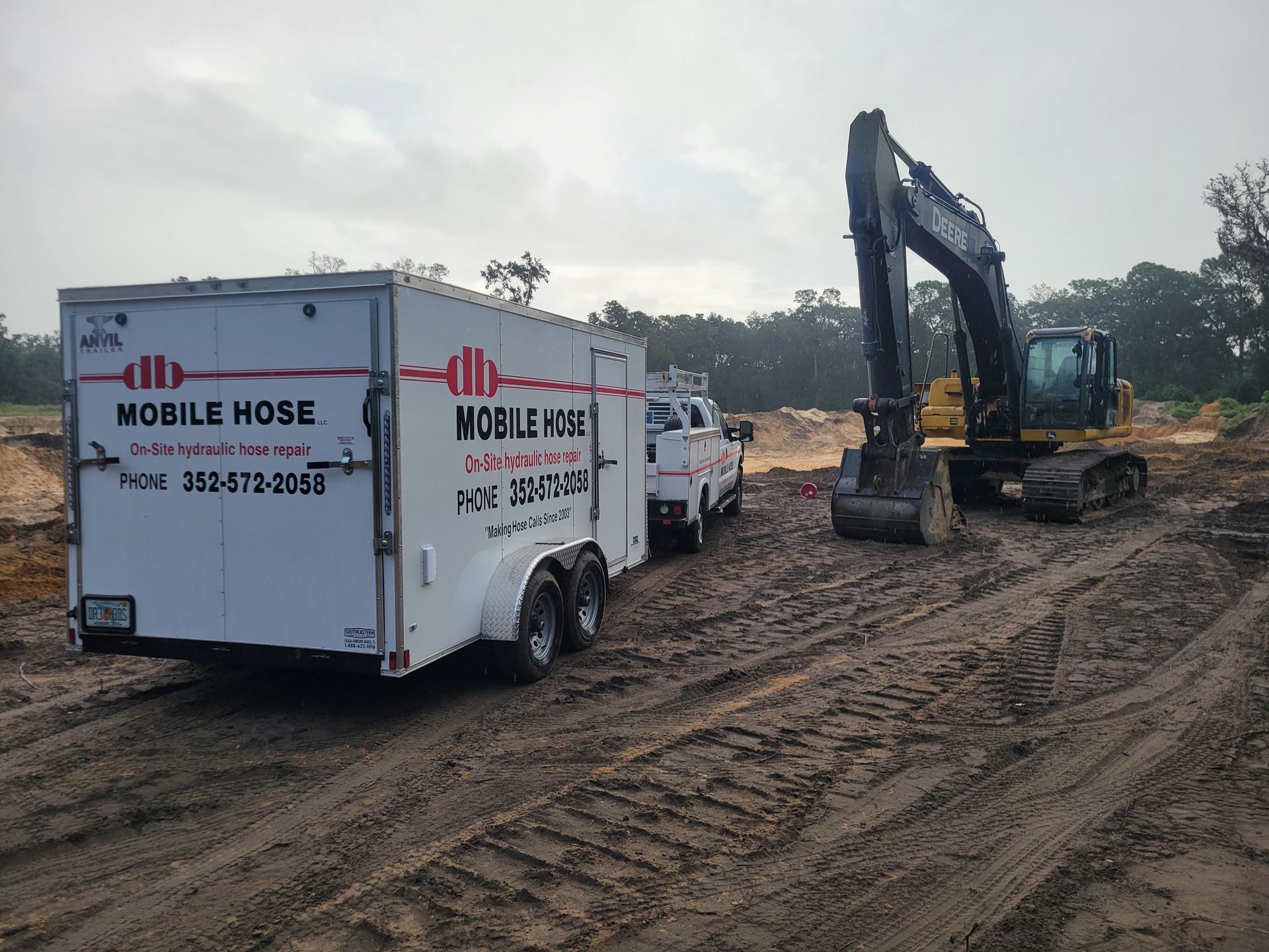 Inside a truck, orange excavator arm dominates. Other tools and equipment fill the space.