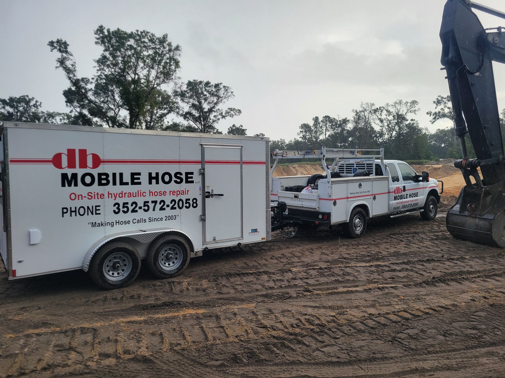 White truck towing a trailer labeled 