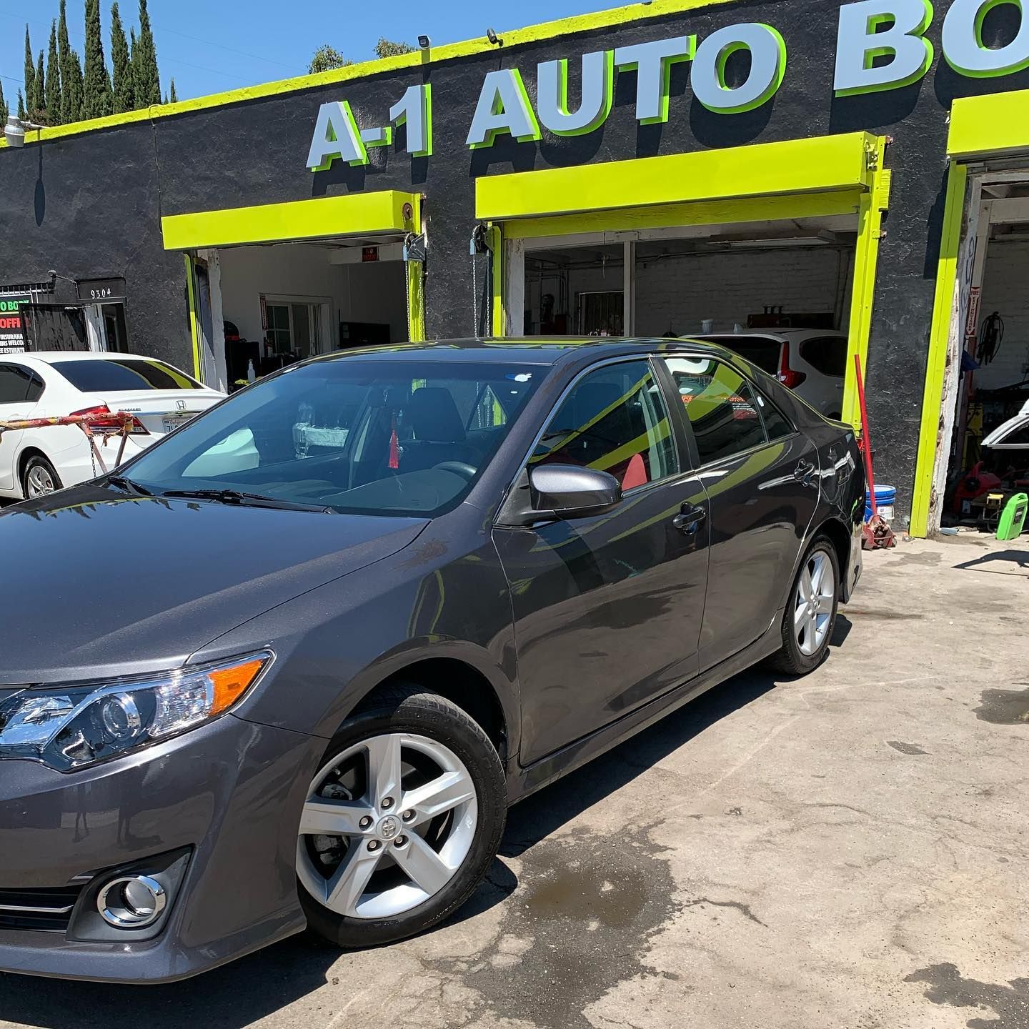 A car is parked in front of a building that says a1 auto