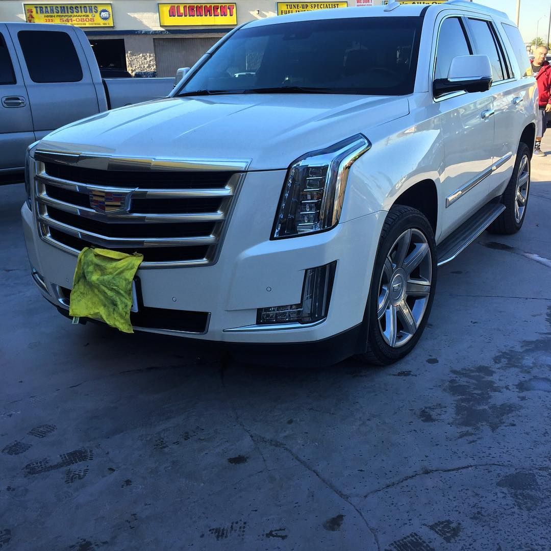 A white suv is parked in front of a building that says fireway
