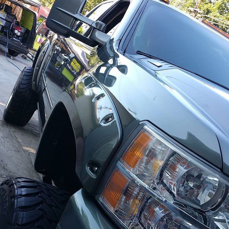 A black truck is parked in a parking lot
