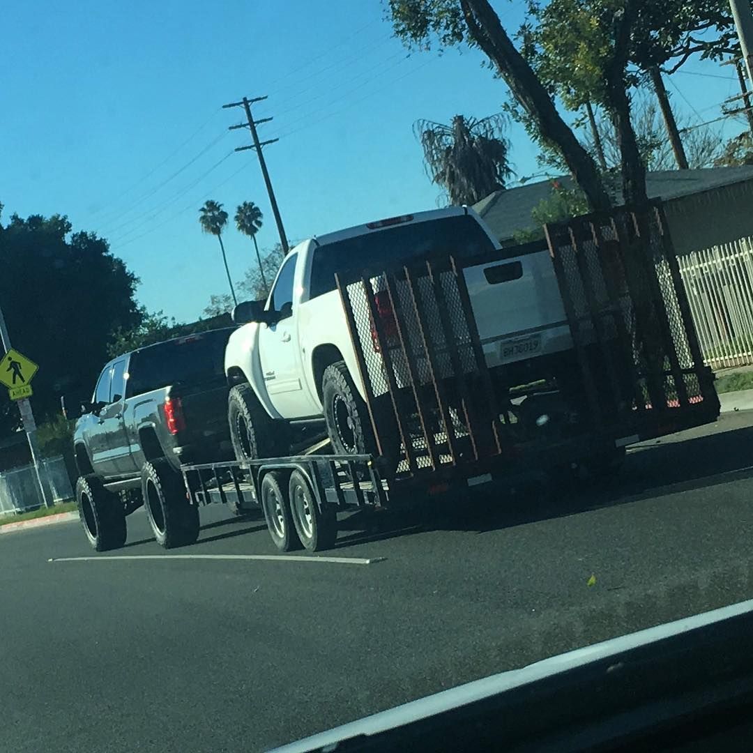 A truck with a trailer attached to it is driving down the road