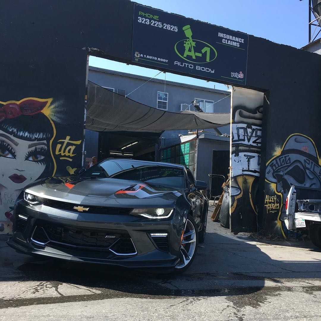 A car is parked in front of a building with graffiti on it.