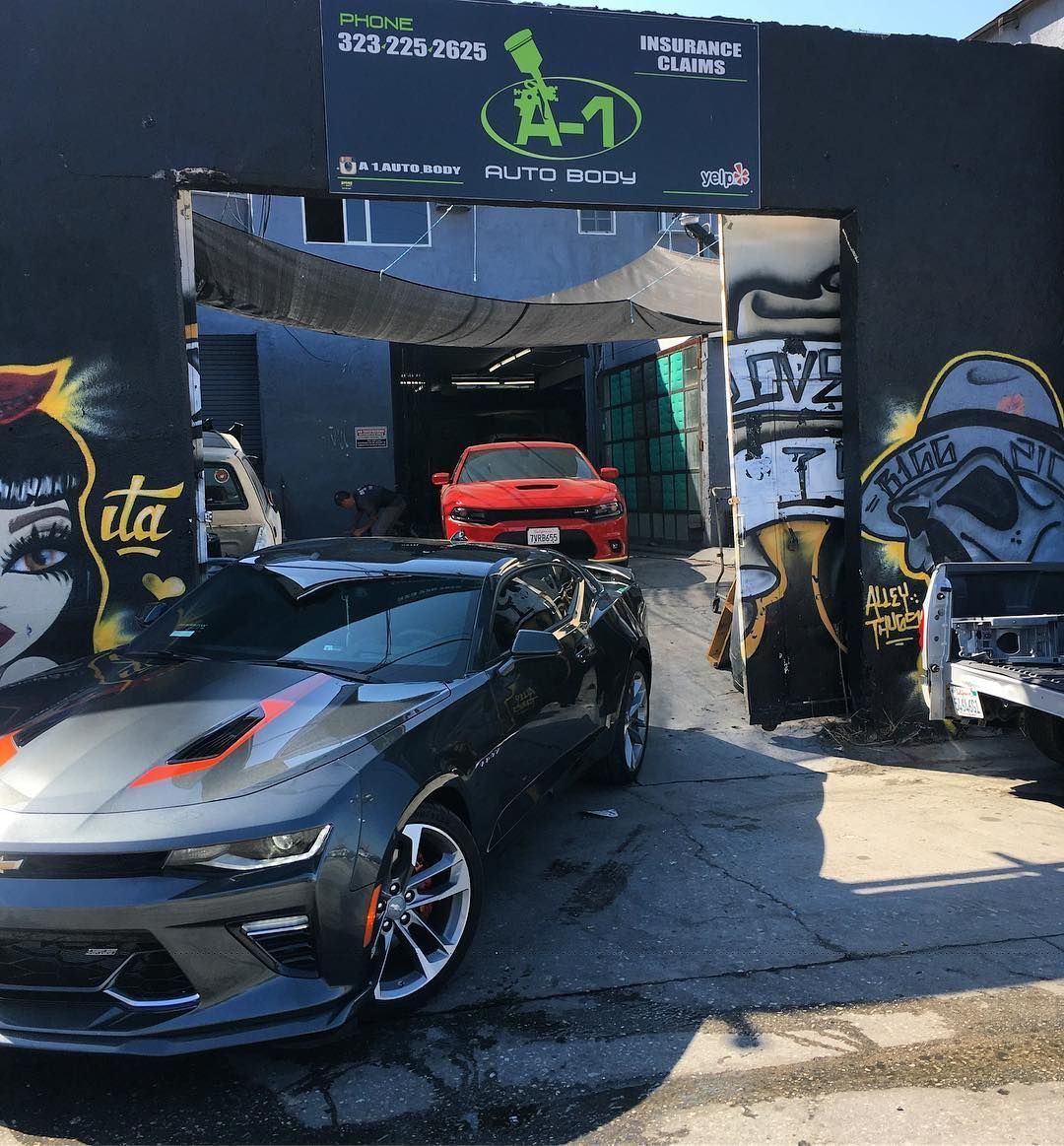 A car is parked in front of a building with graffiti on it