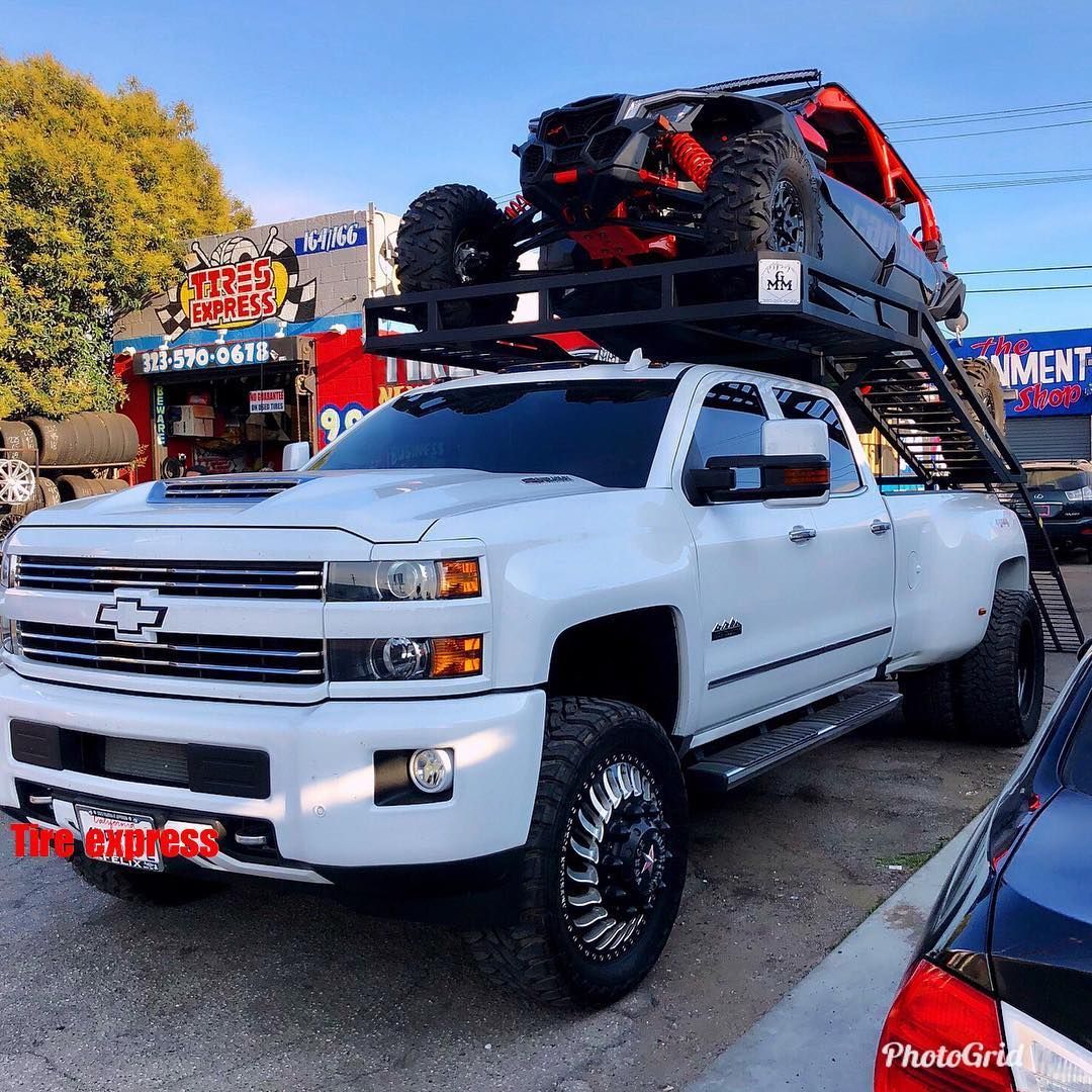 A white truck with a jeep on top of it