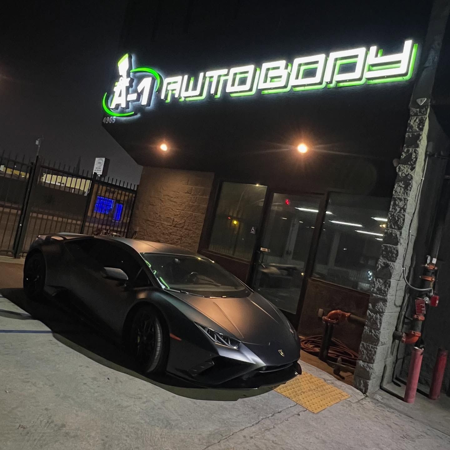 A car is parked in front of a building that says autobody