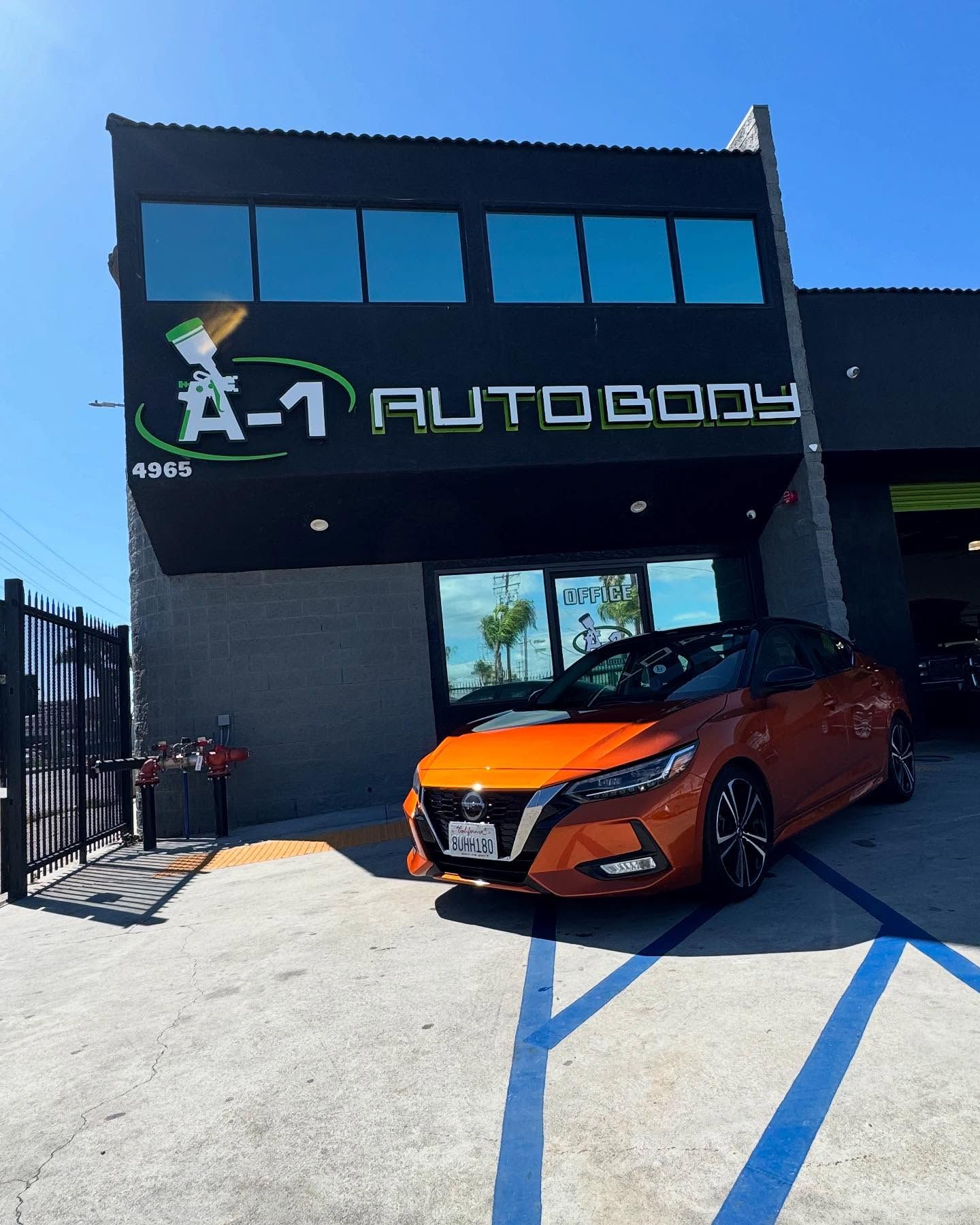 A car is parked in front of a building that says a-1 auto body