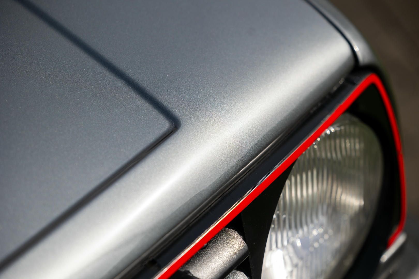 A close up of a car hood and headlight