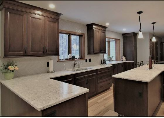 Kitchen with dark brown cabinets, light countertops, and wooden floors.