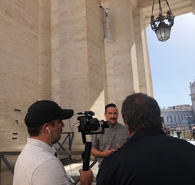 A man is holding a camera and talking to another man