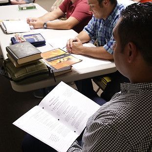 A man is sitting at a table reading a book