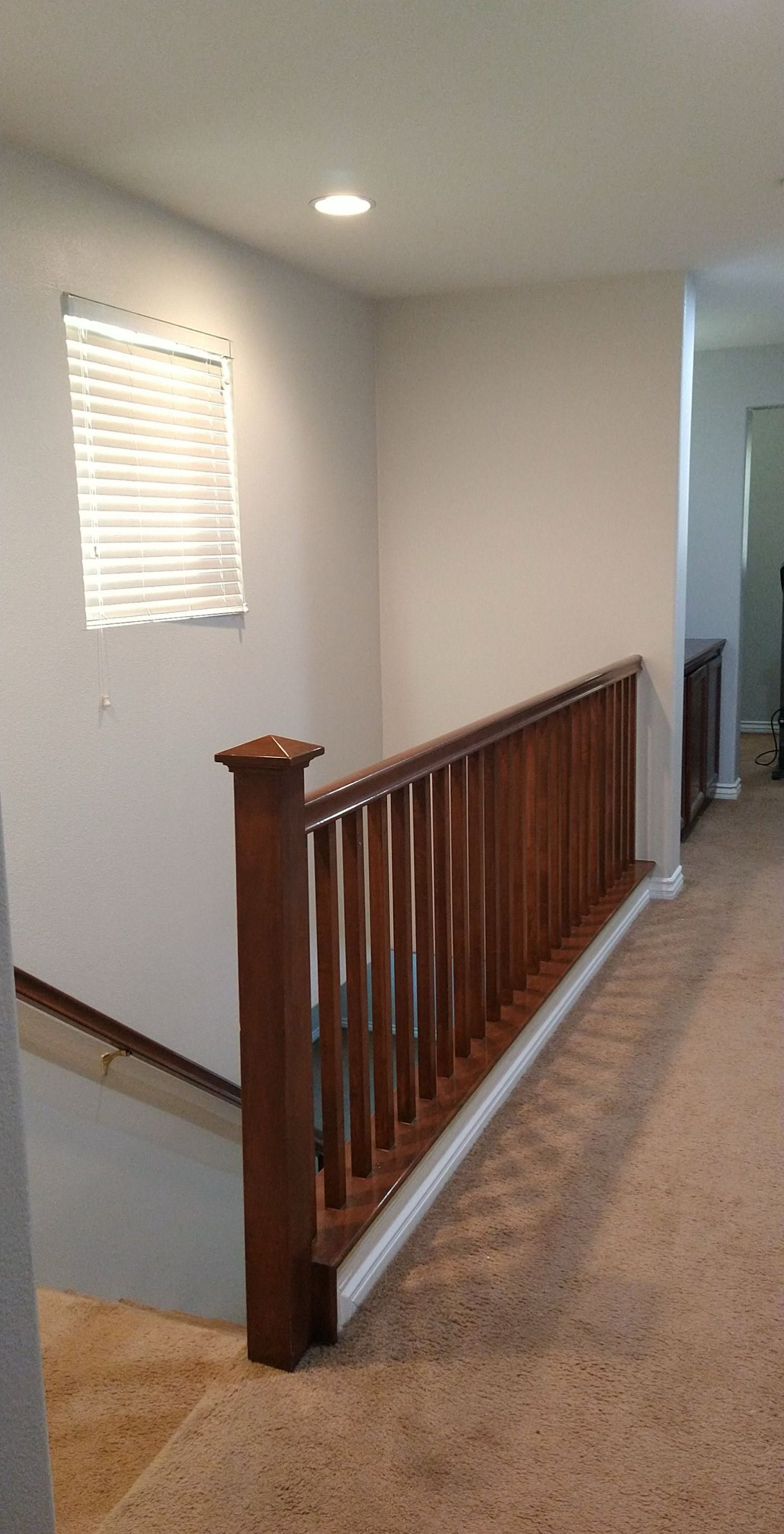A hallway with a wooden railing that got a new coat of paint.
