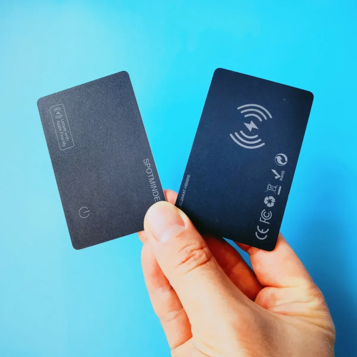A person is holding a wallet tracker card in their hand