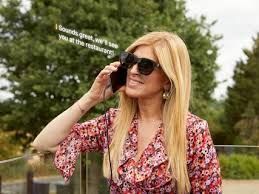 A woman wearing sunglasses is talking on a cell phone.