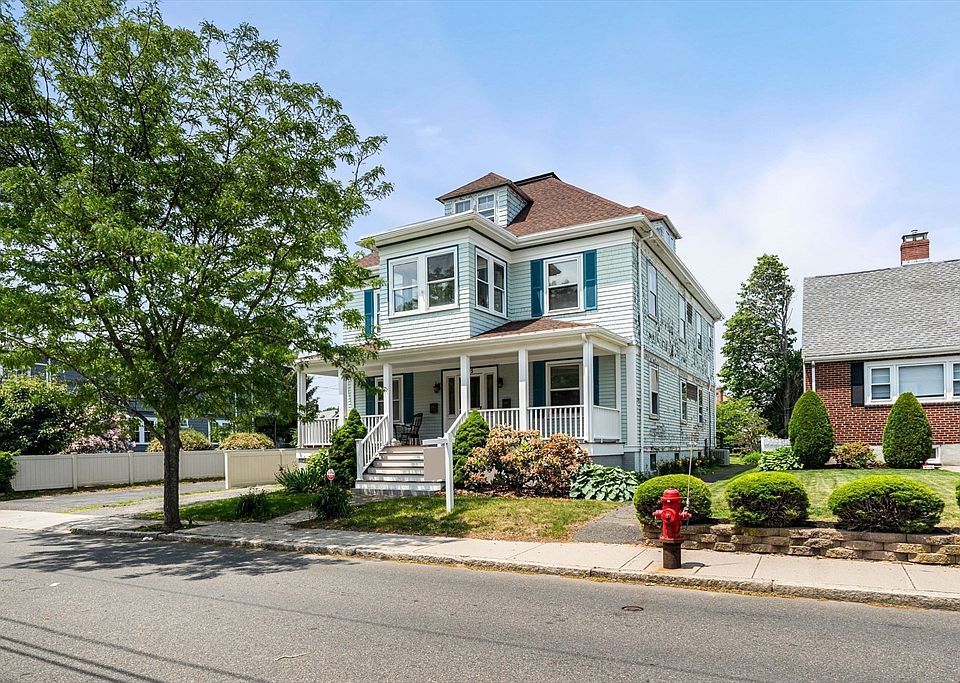A house in the middle of a field with trees in the background.