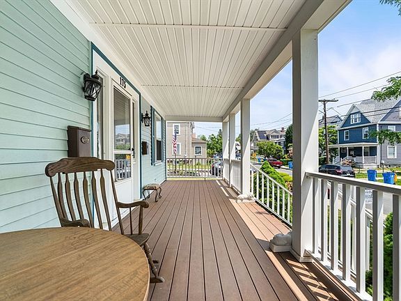 A large house with a driveway and trees in the background