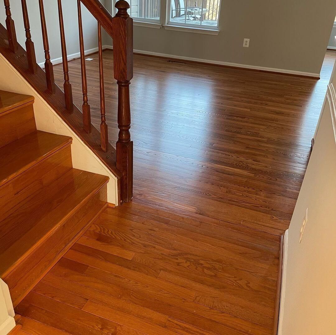 Wooden staircase and hardwood floor in a well-lit interior space.