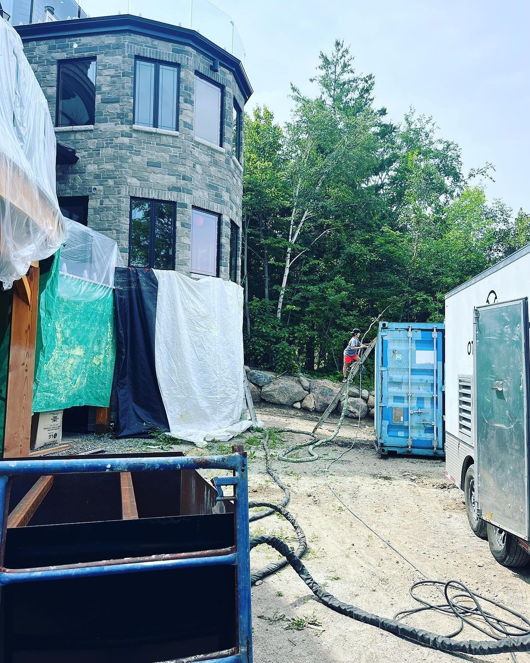 A large brick building is being built in the middle of a forest.
