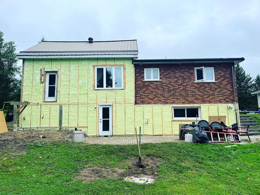 A house is being built with green insulation and brick.