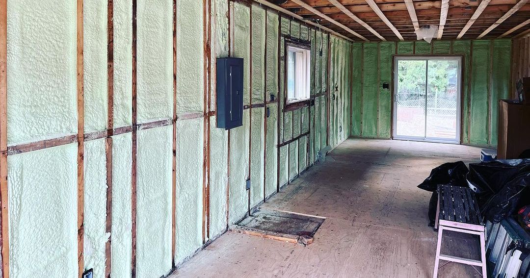 A room with green walls and a sliding glass door.