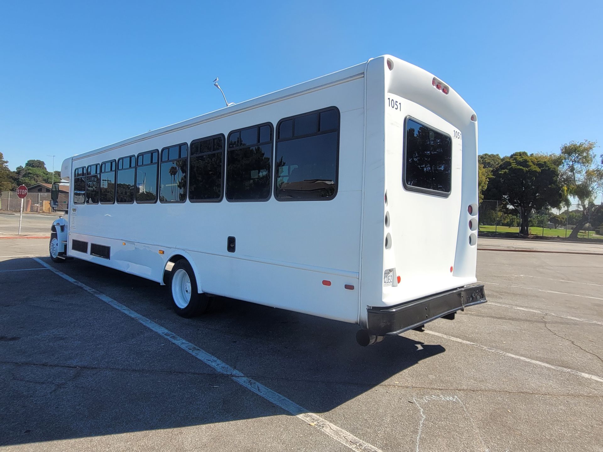 A white bus is parked in a parking lot