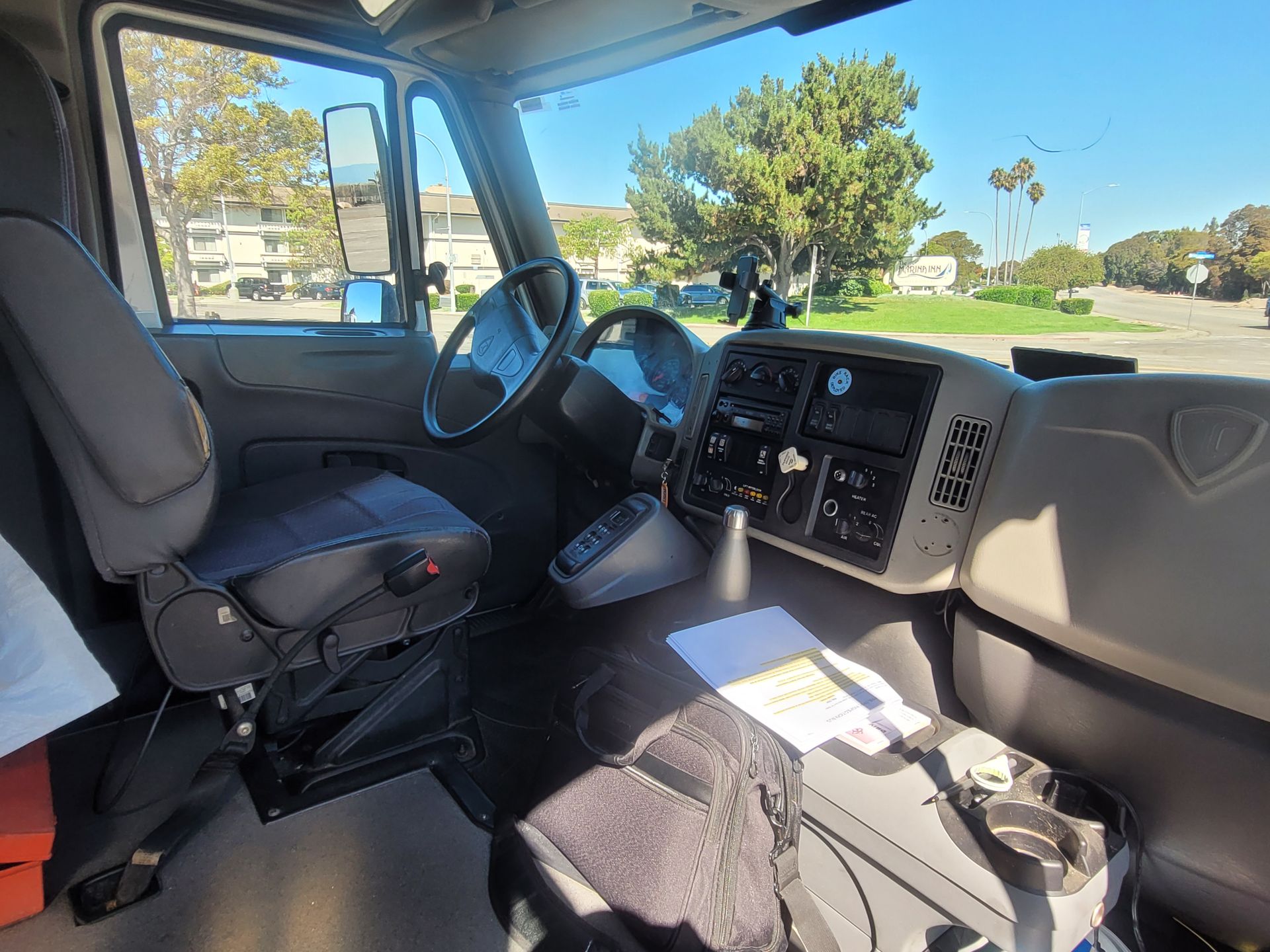 The inside of a truck with a steering wheel and dashboard.