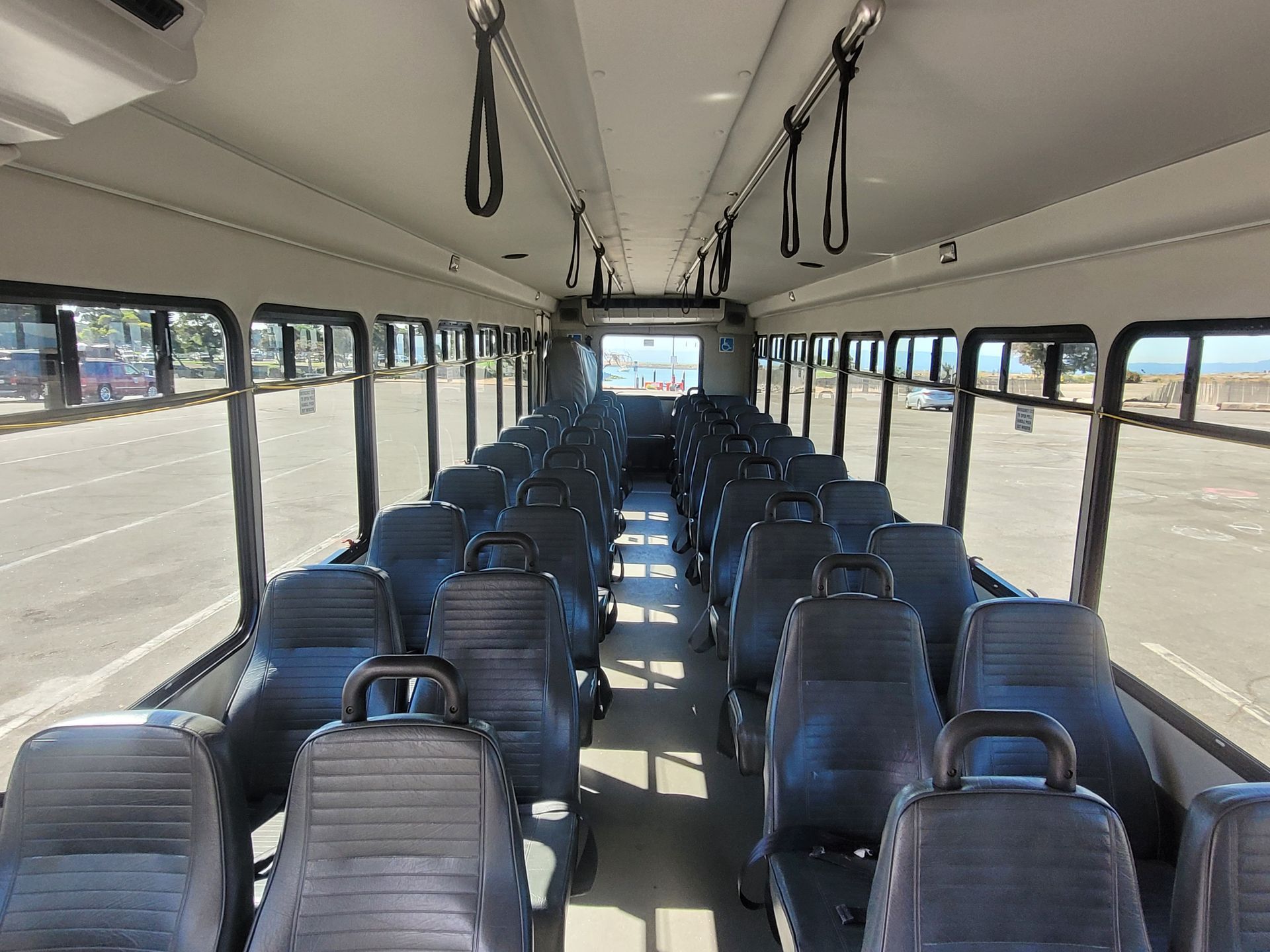 The inside of a bus with a lot of seats and a lot of windows.