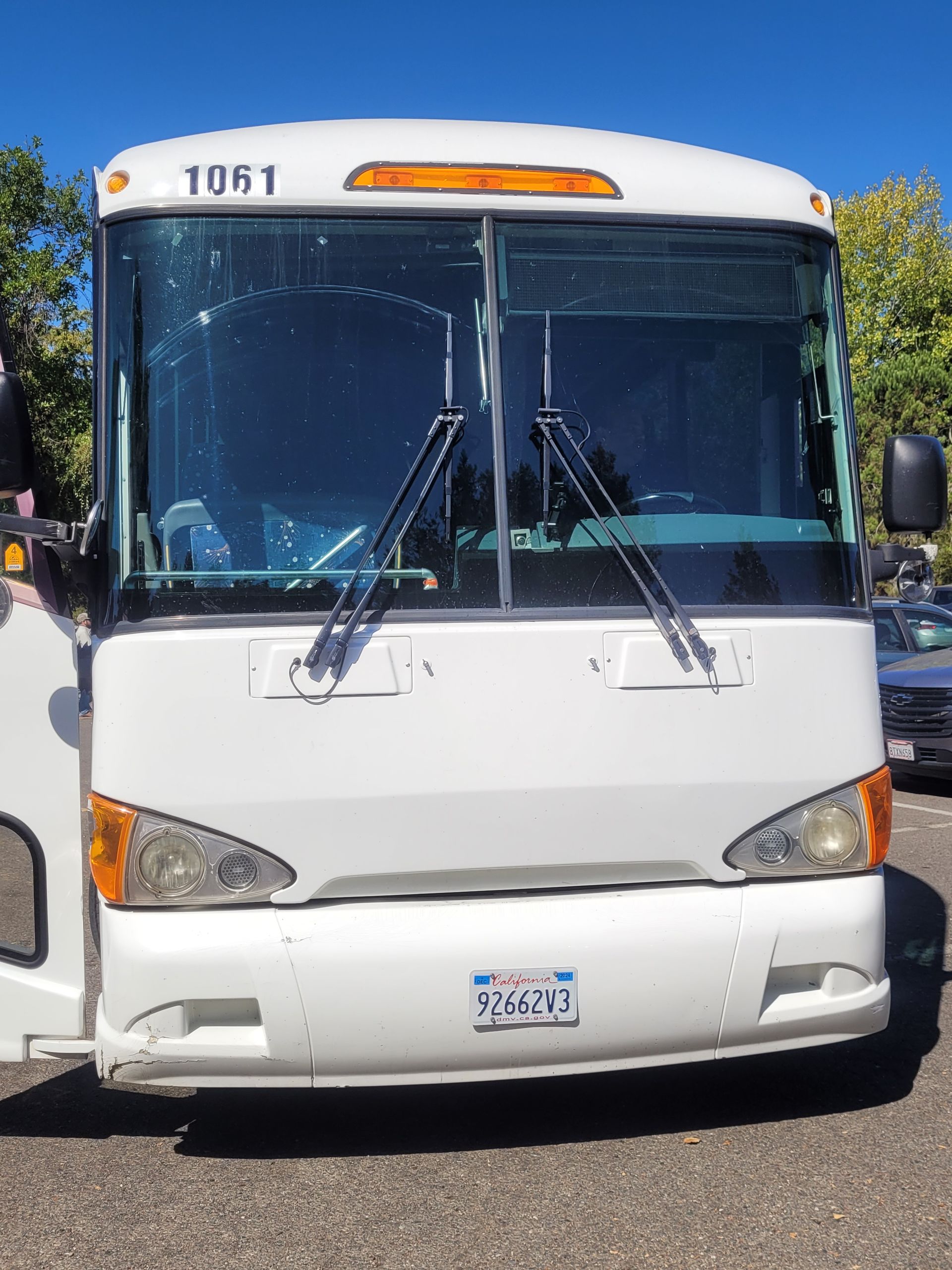 A white bus with 1061 on the front is parked in a parking lot