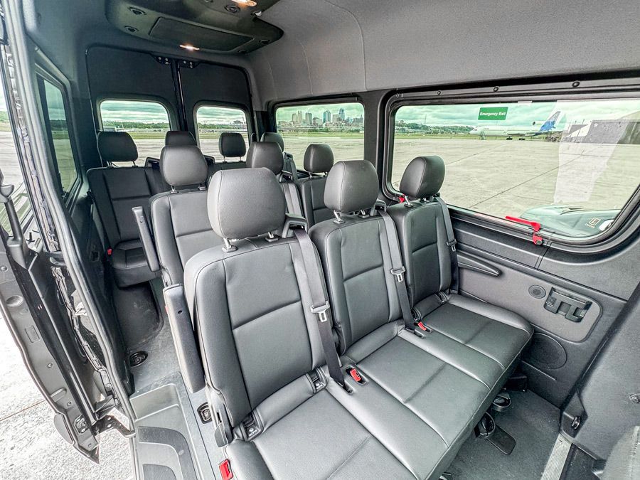 The inside of a van with a lot of seats and a window.