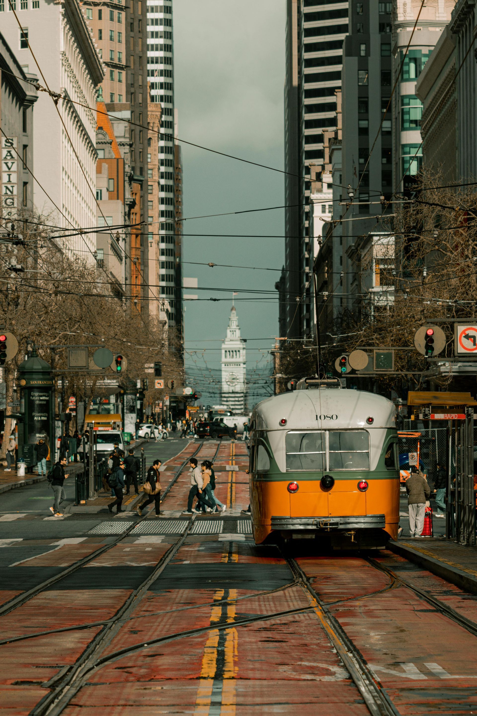 A trolley is going down the tracks in a city.