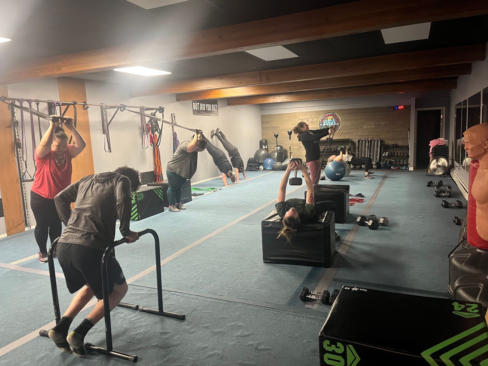 A group of people are doing push ups together in a gym.