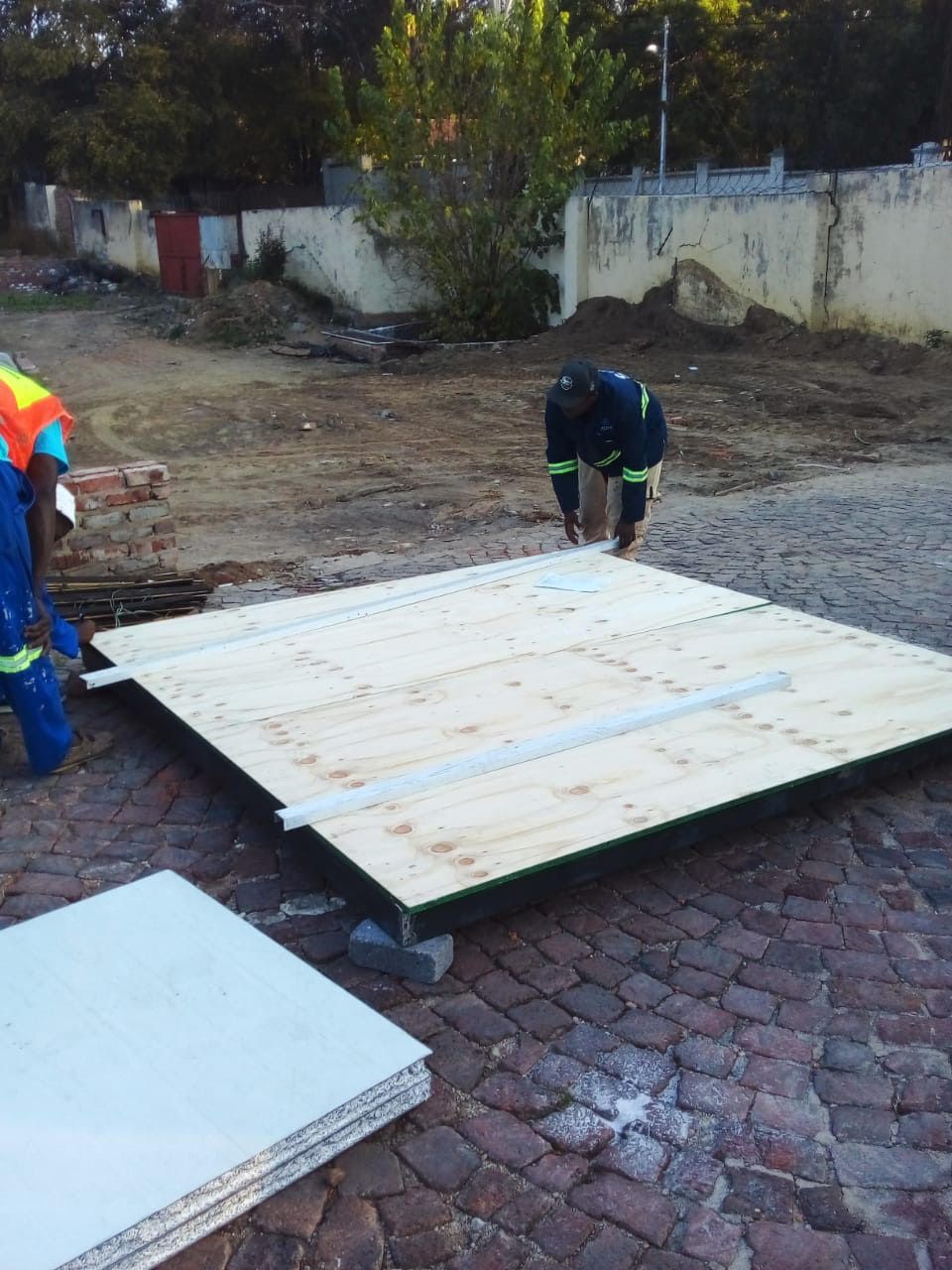 Two men are working on a large piece of wood
