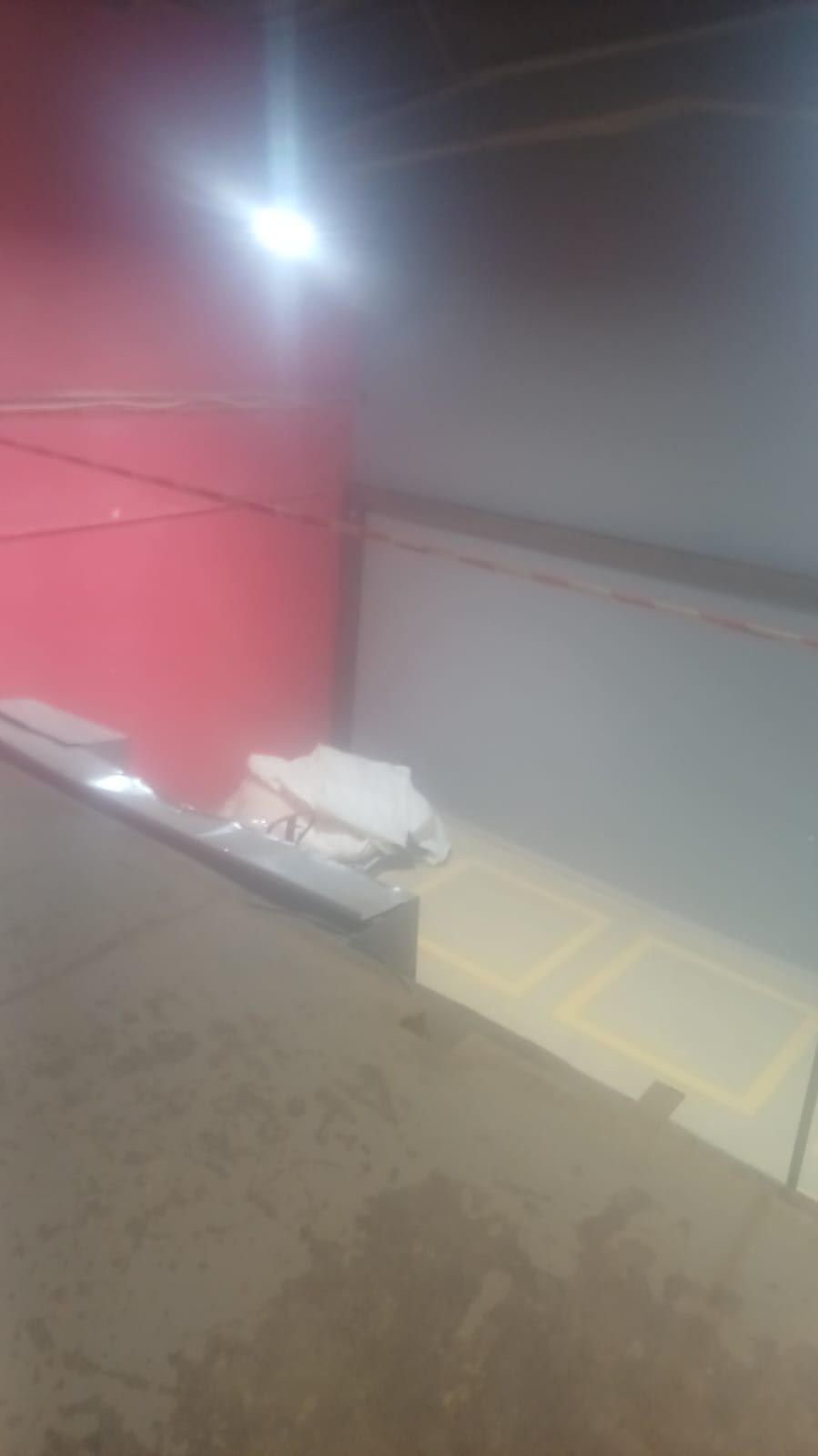 A foggy room with a red wall and a light on the ceiling.