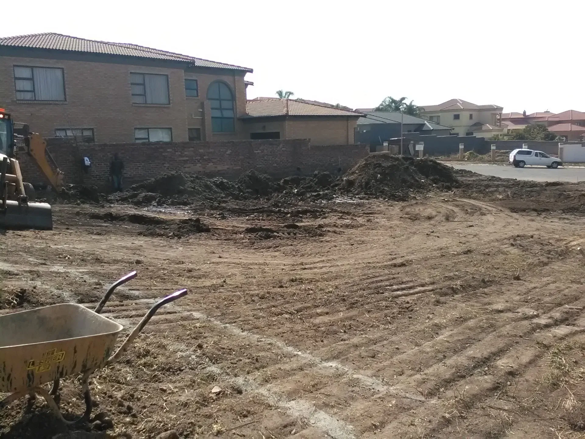 A construction site with a wheelbarrow in the foreground