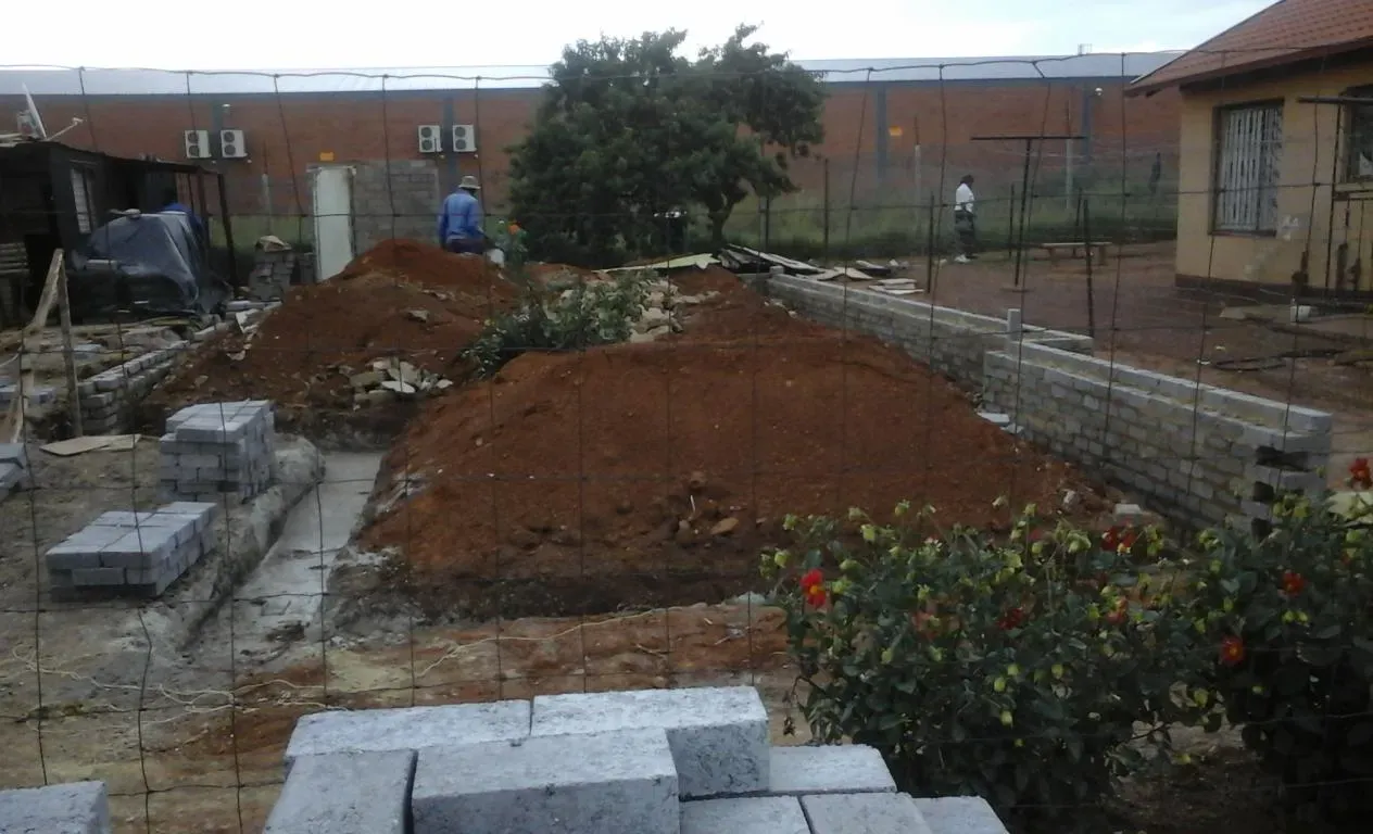 A pile of dirt is sitting in front of a building under construction.