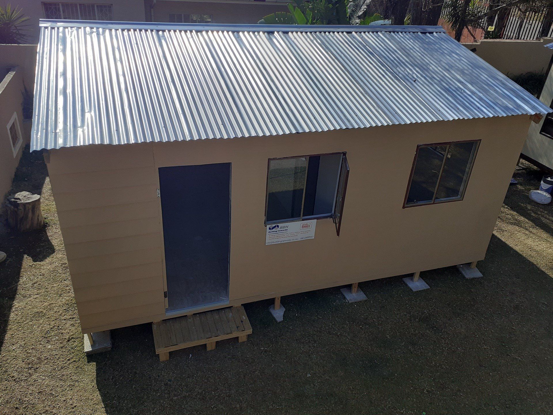 A small house with a metal roof and a door
