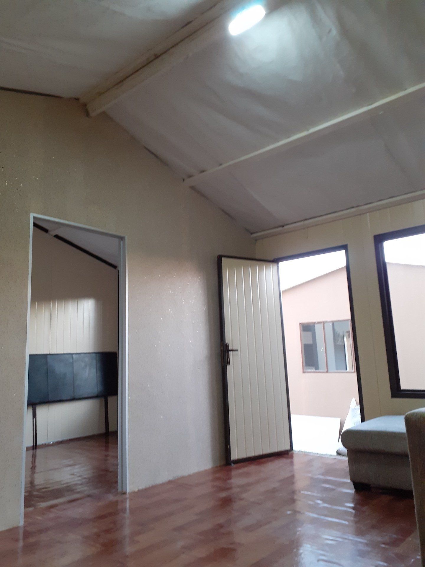 A living room with hardwood floors and a white ceiling