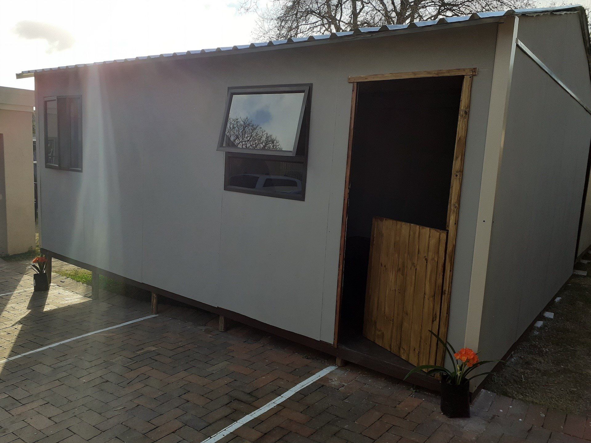 A small white building with a wooden door and window.