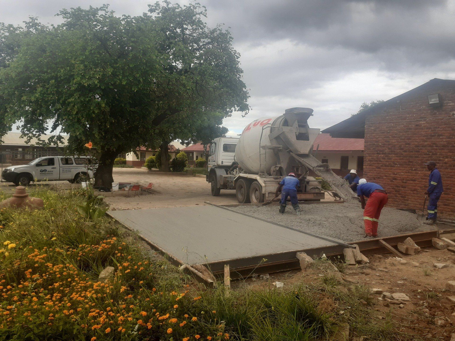 A concrete mixer is being used to pour concrete into the ground