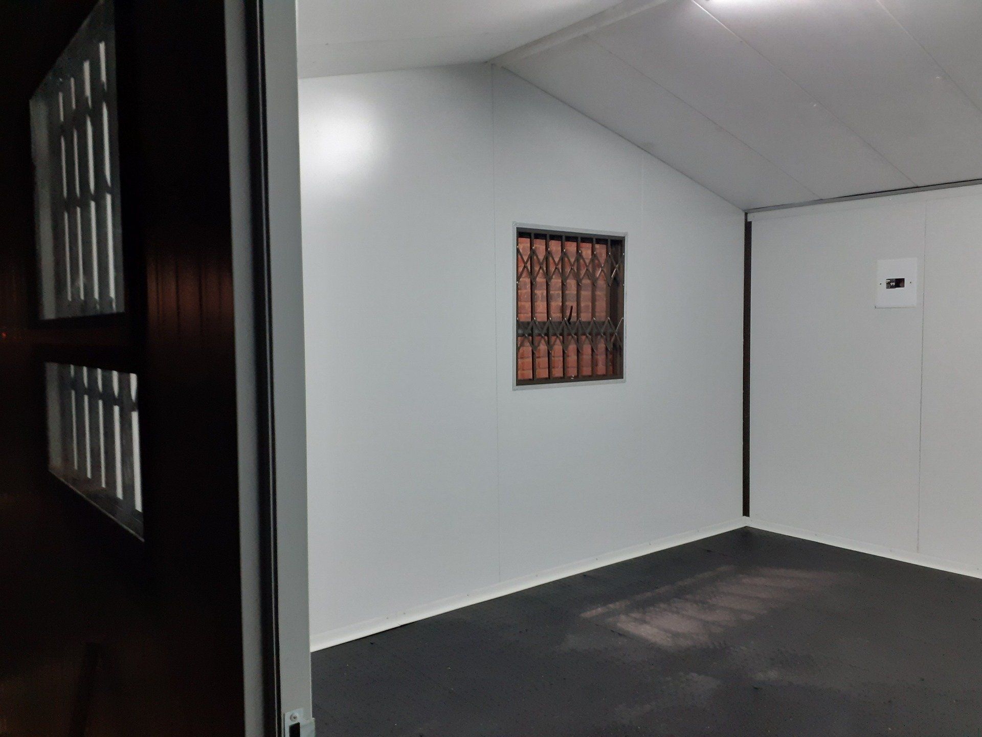 An empty room with a window and a black floor