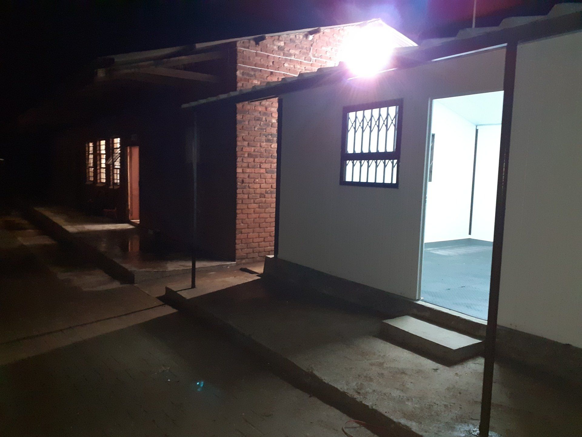 A house with a light on the side of it at night