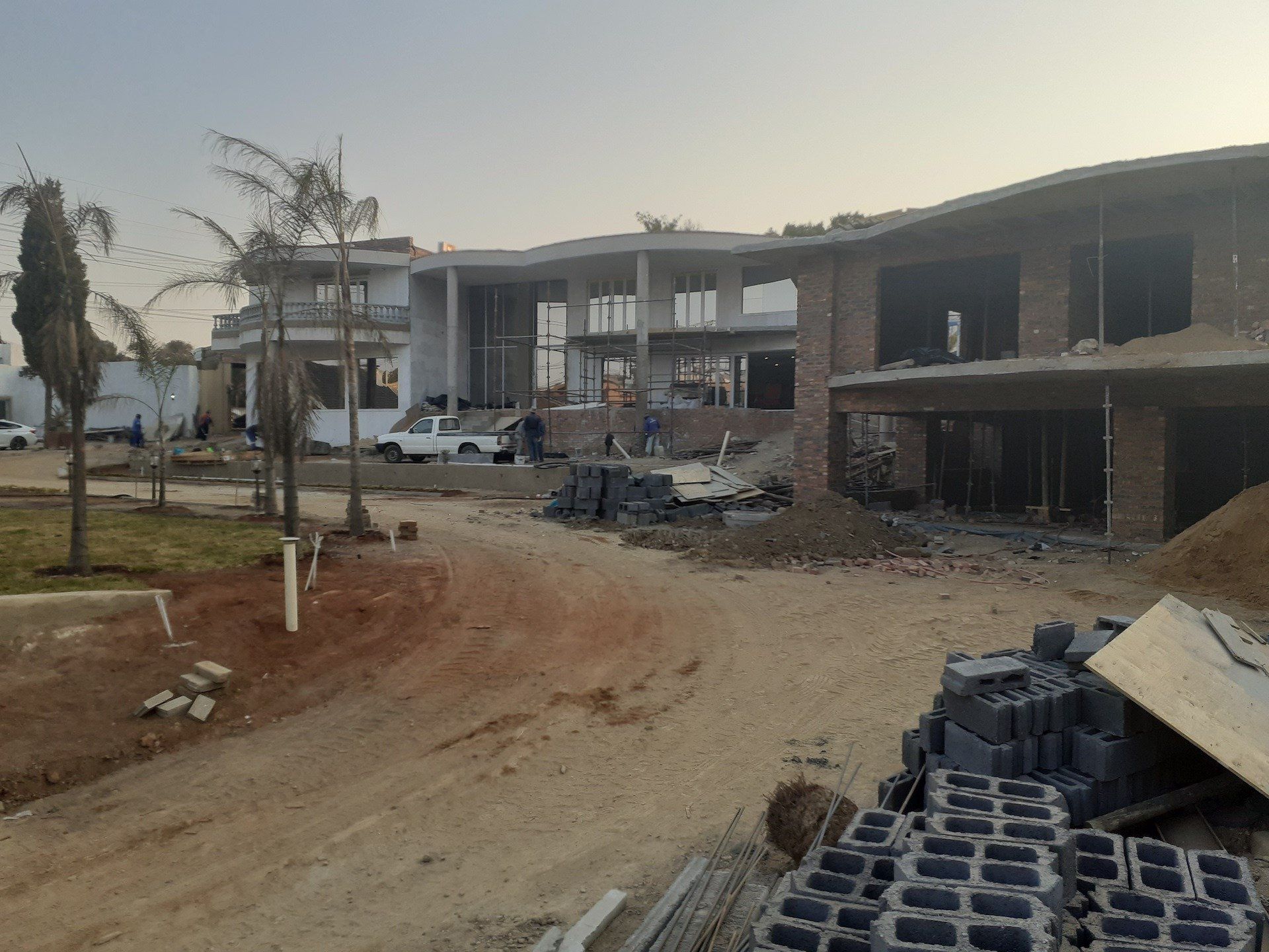 A large building is being built in the middle of a dirt road.
