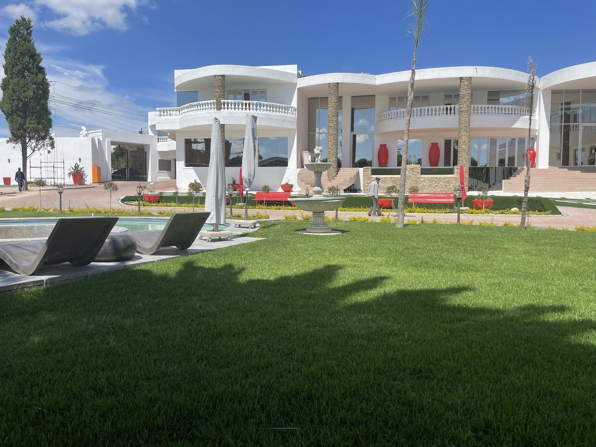 A large white house with a swimming pool in front of it