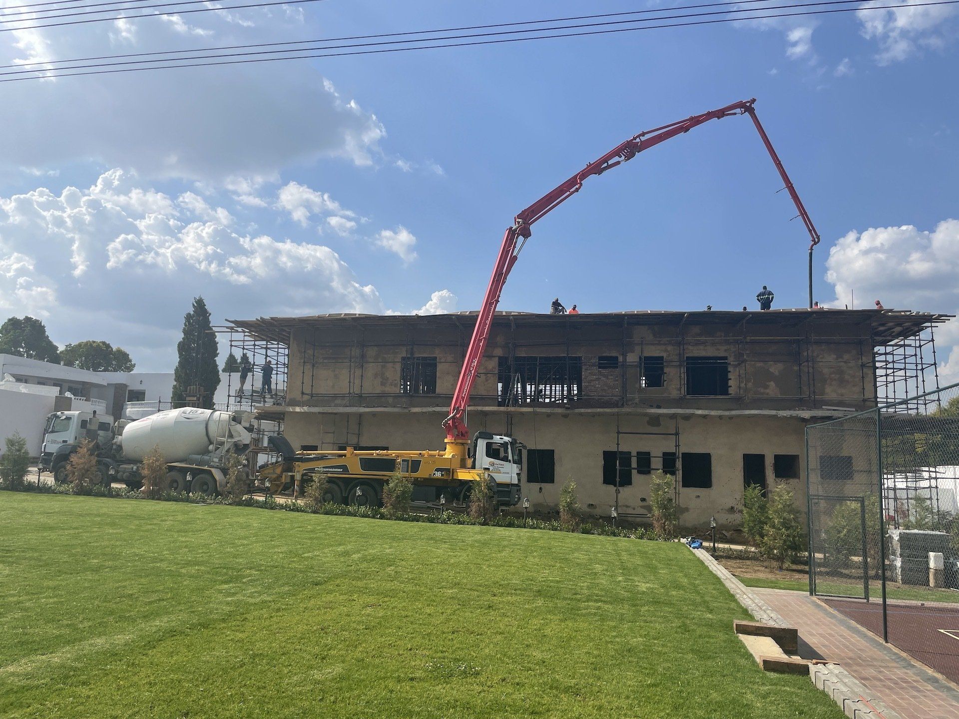 A concrete pump is being used to pour concrete into a building under construction